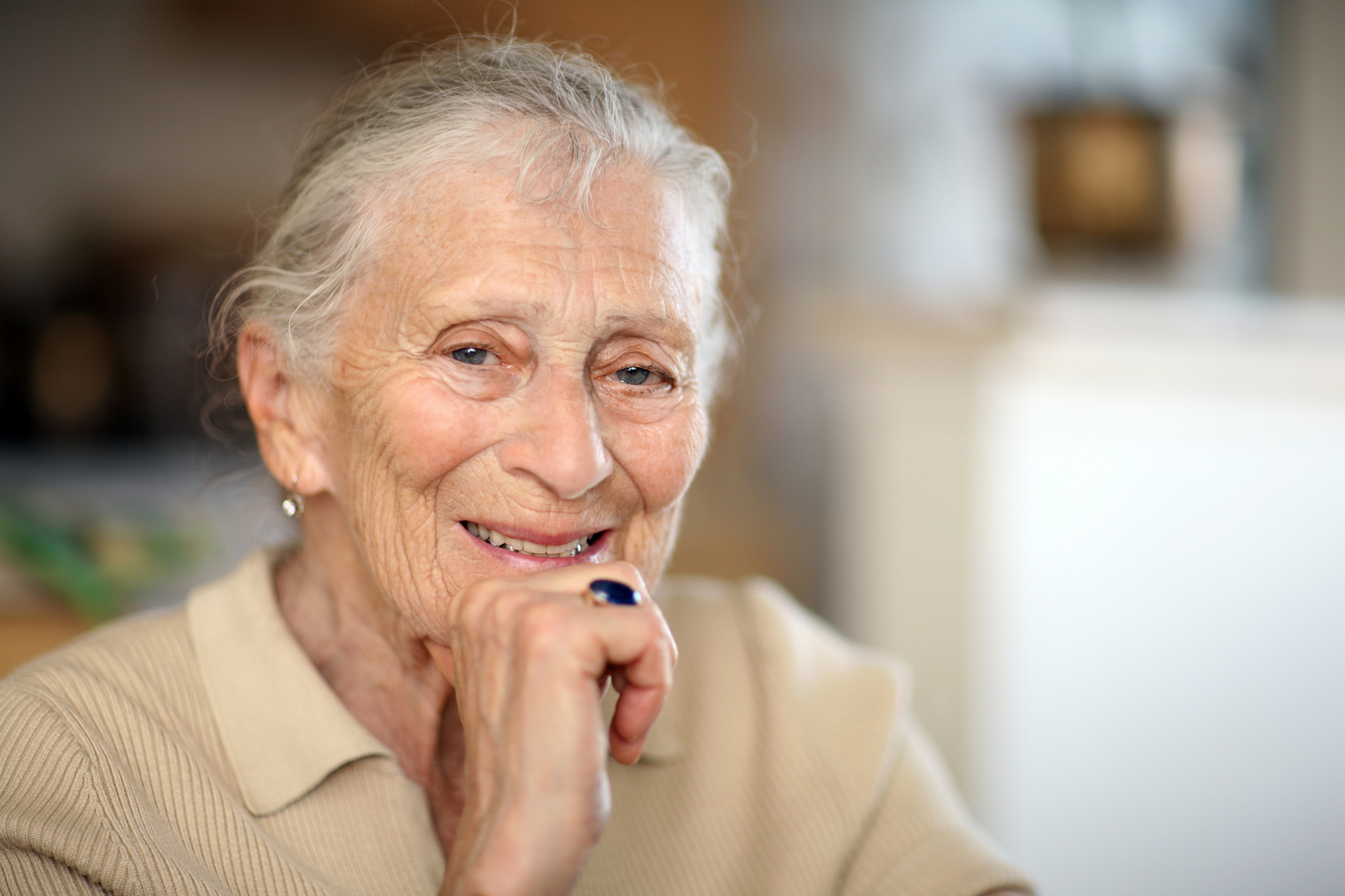 older woman with hand on chin, smiling