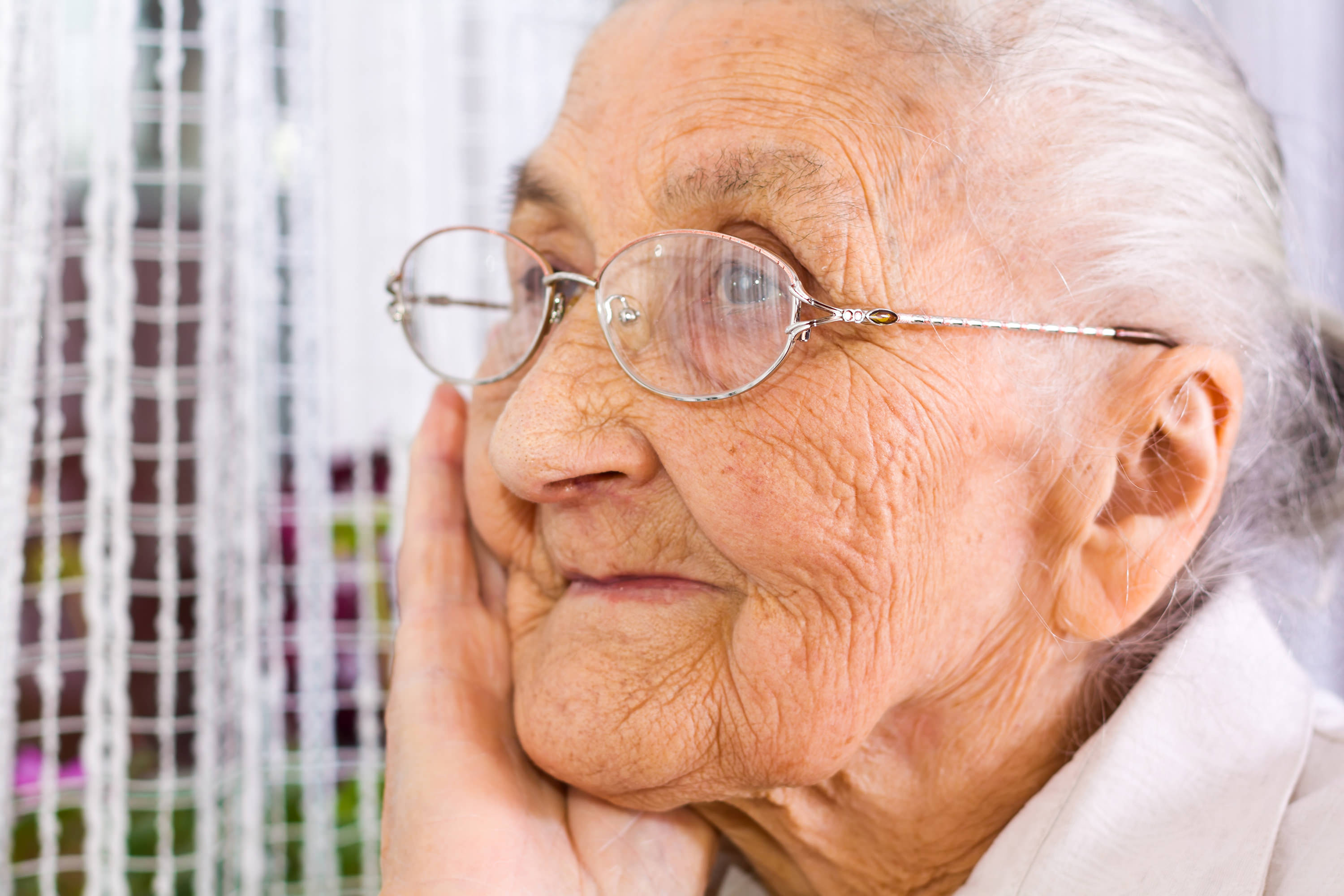 older woman with glasses thinking