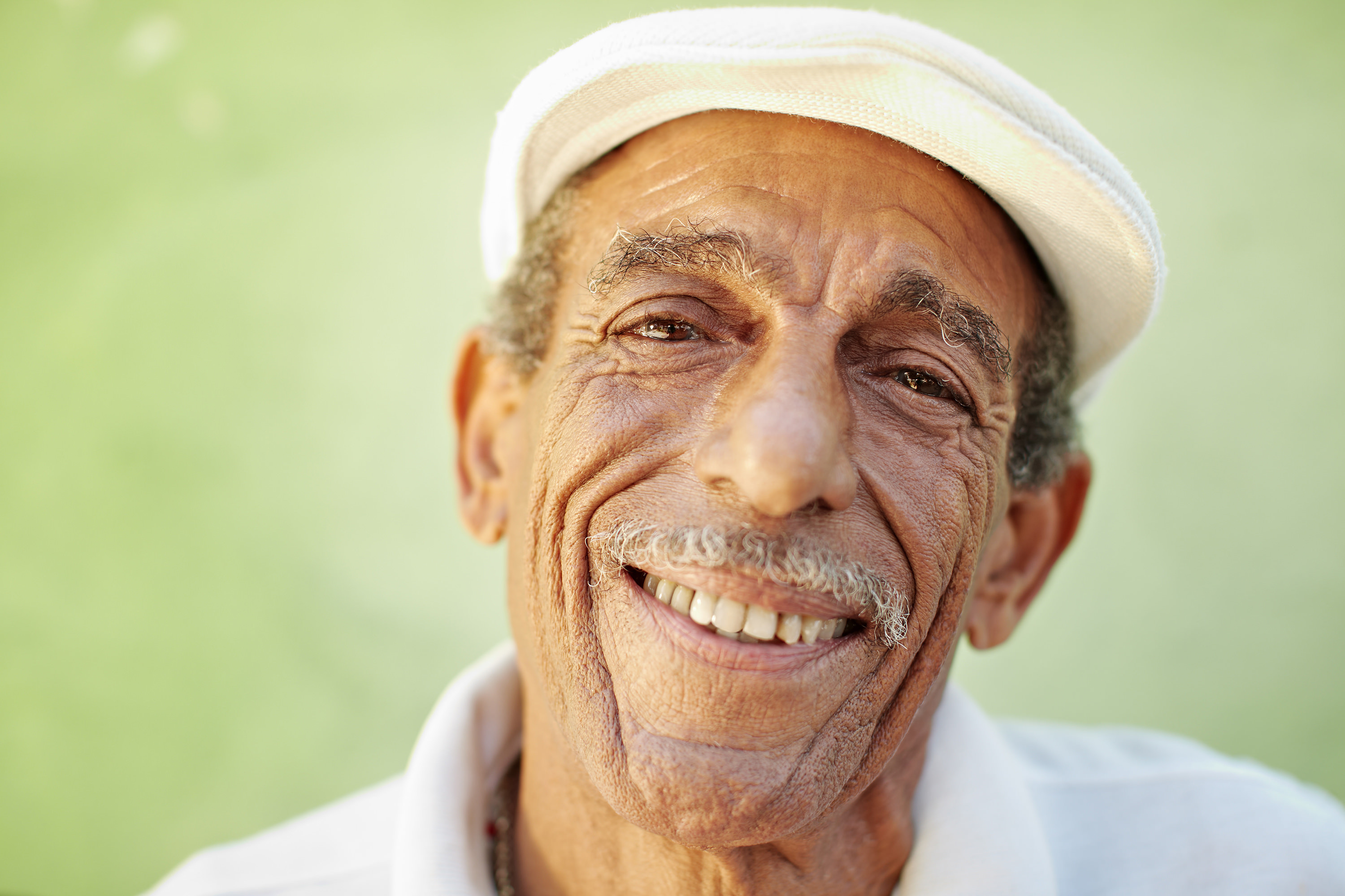 older man with bunnet smiling