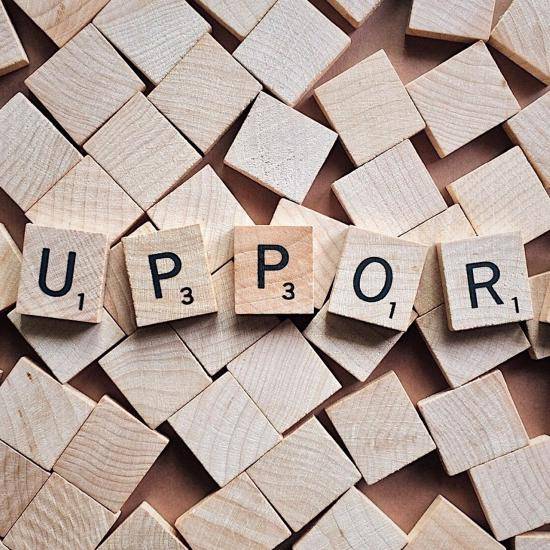The word 'support' written in Scrabble letters