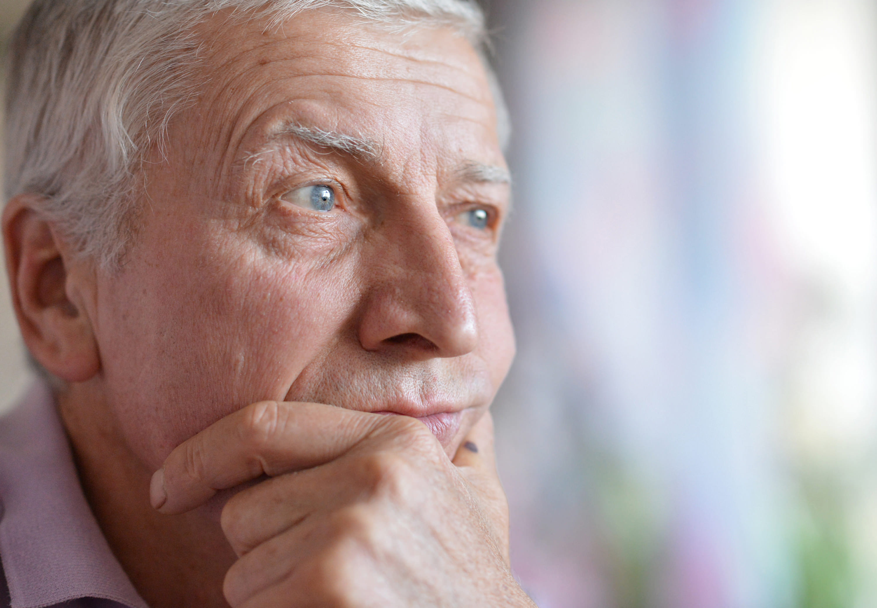 concerned older man with hand on chin