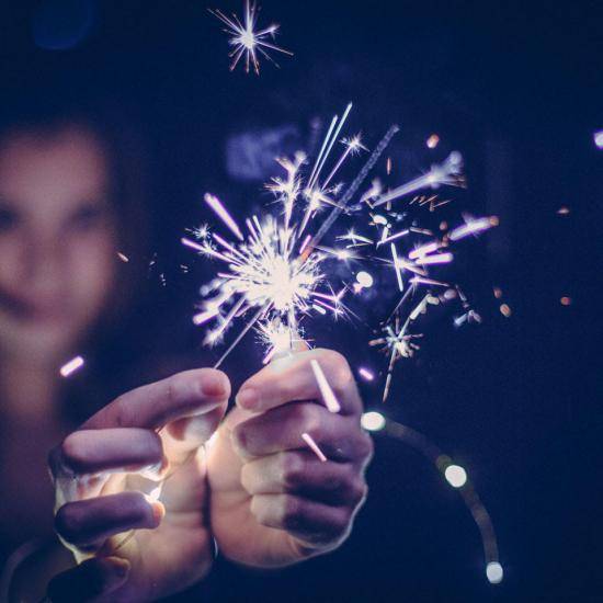 Person holding a lit sparkler