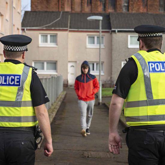 Young man approaching two police officers