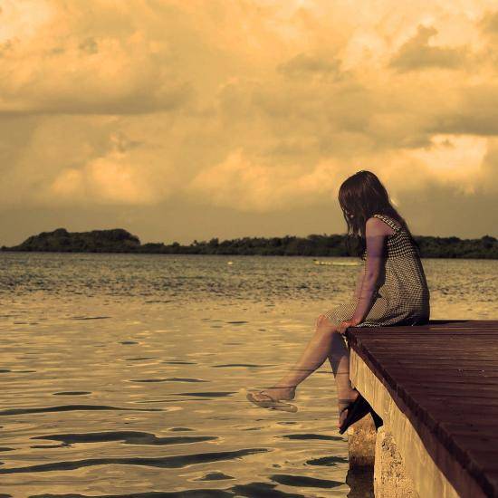 Image of girl sitting on a pier by Tyrone Lambert from Pixabay 