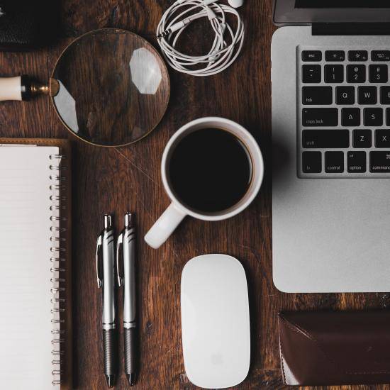 image of a desk, laptop and other work materials