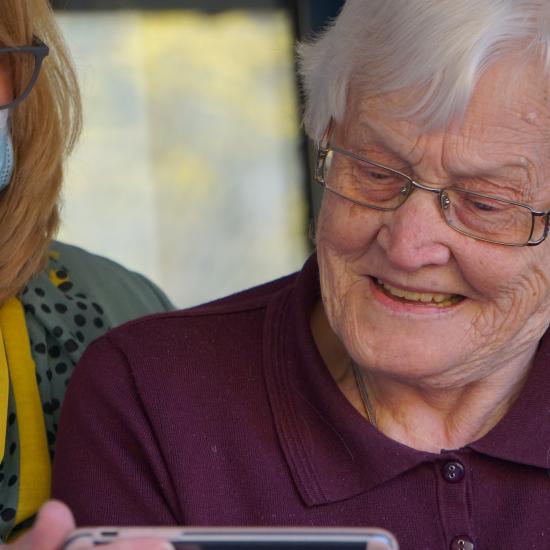 Woman with grey haid looking at phone