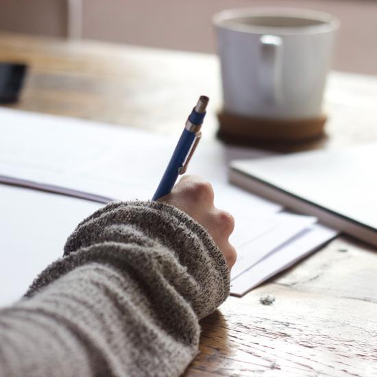 Closeup of hand, writing on a notepad