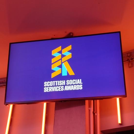 a wall mounted television with Scottish Social Services Awards