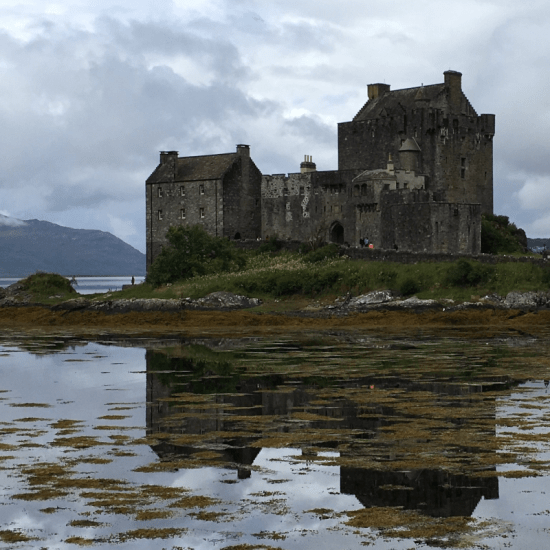 a lakeside castle reflected in the water
