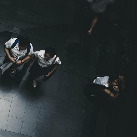 a top down photograph of some students walking with one stood facing up towards the camera