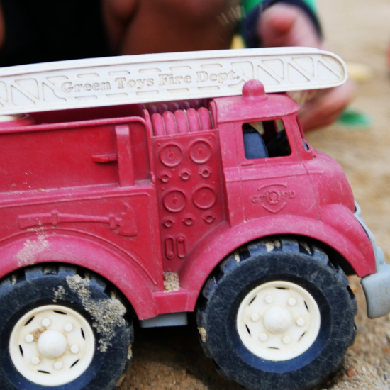 a toy fire truck in a sandpit
