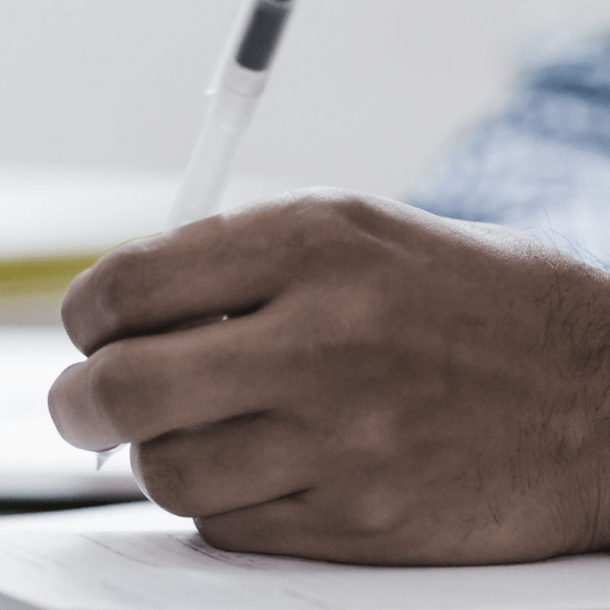 a hand taking ntoes on a notepad