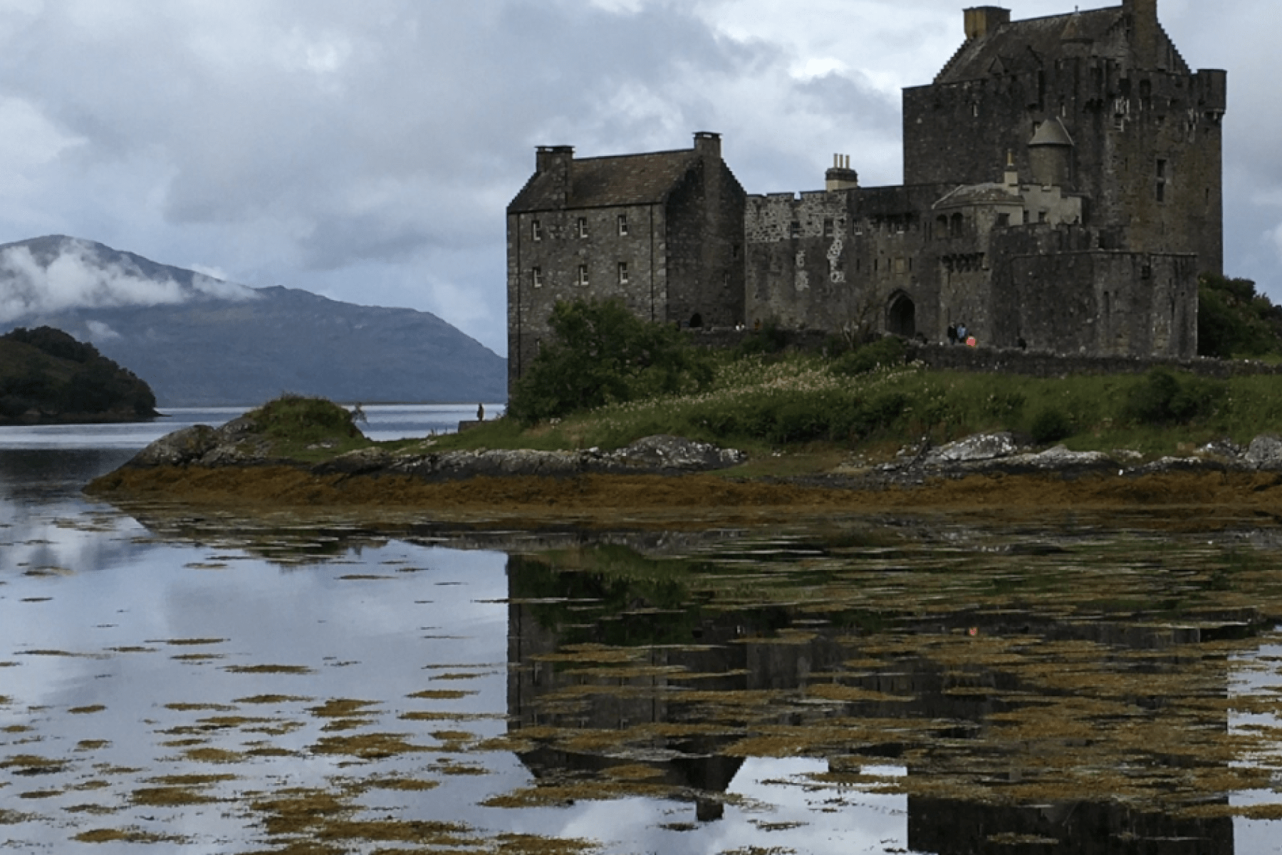 a lakeside castle reflected in the water