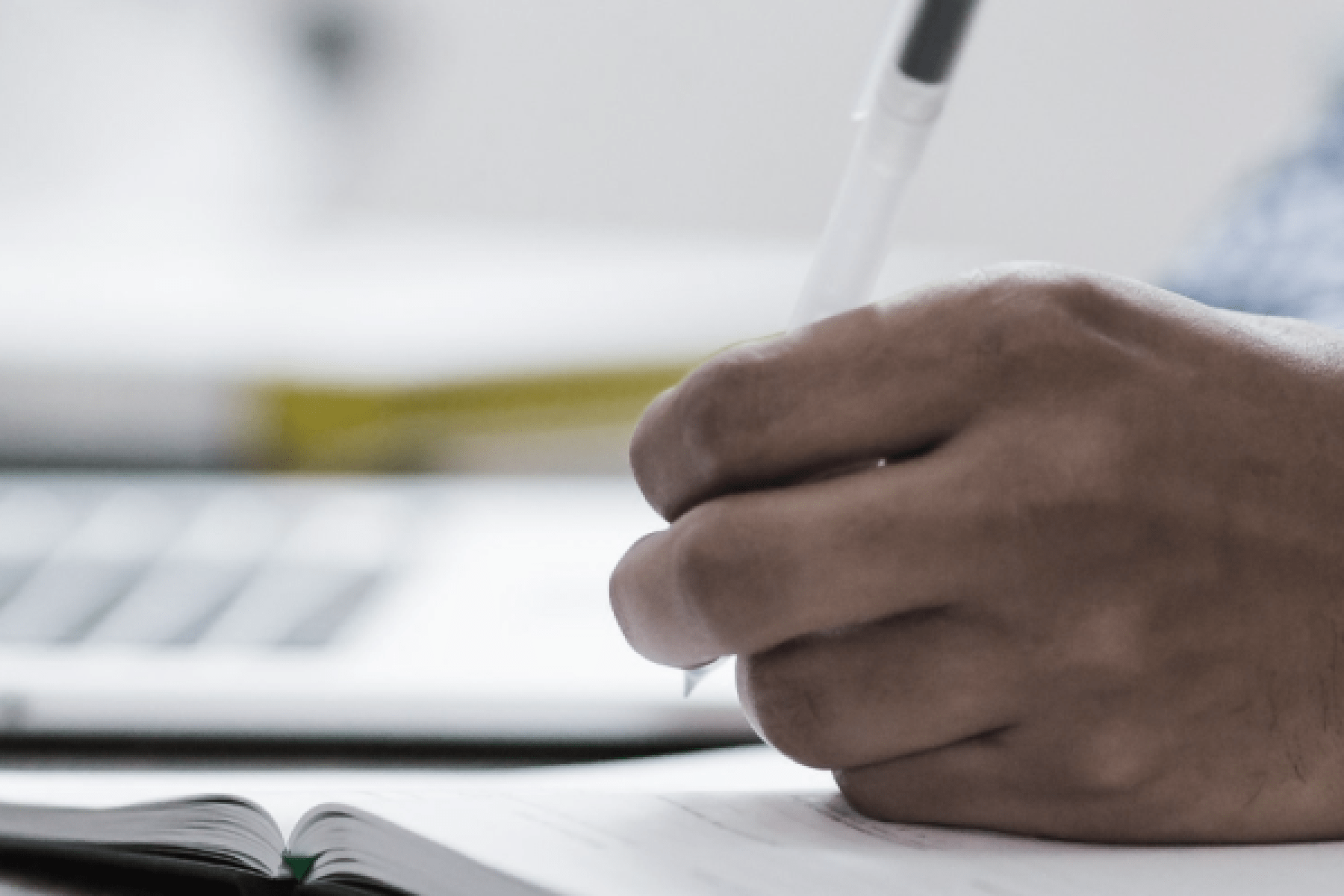 a hand taking ntoes on a notepad