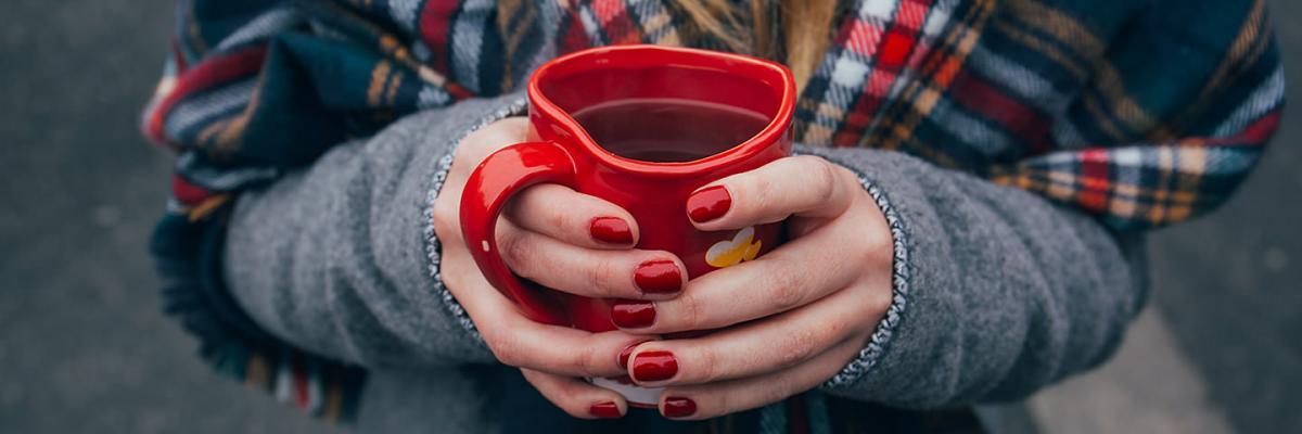 Hands hold a cup of tea