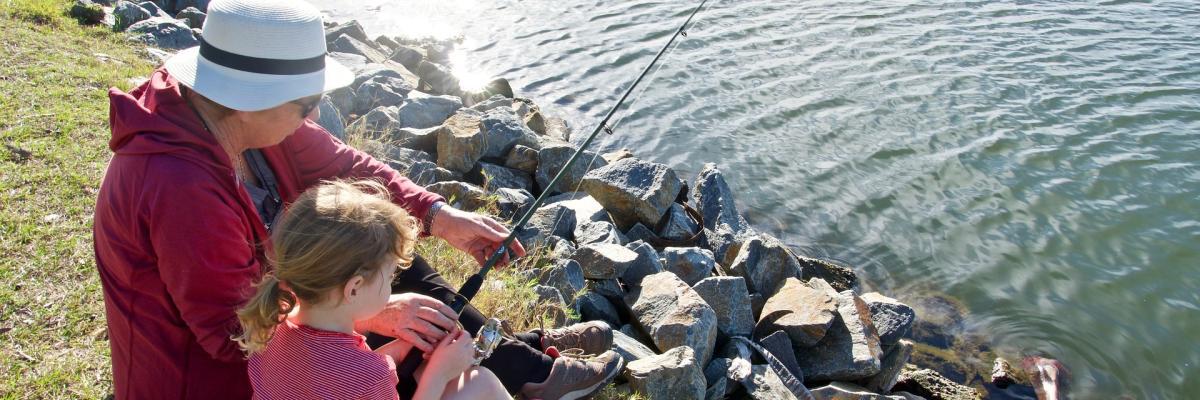 An adult and child fishing