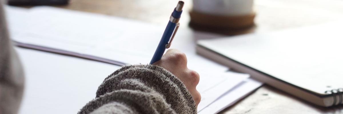 Closeup of hand, writing on a notepad