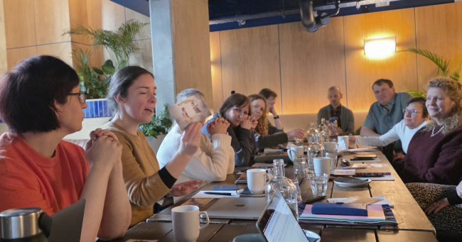 a group of people in discussion around a long table