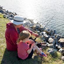 An adult and child fishing