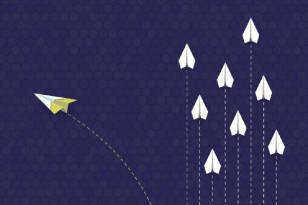 Illustration of paper aeroplanes flying in formation with one breaking off representing change