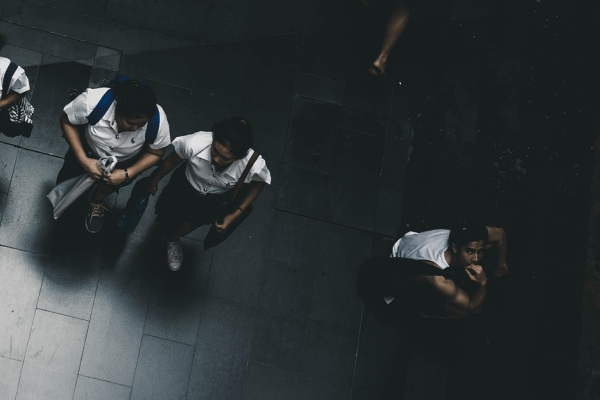 a top down photograph of some students walking with one stood facing up towards the camera