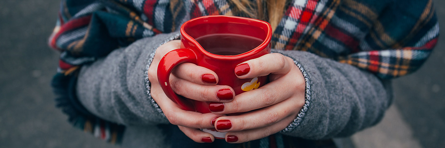 Person drinking tea from heart-shaped mug